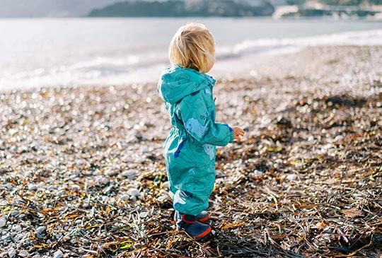Barn i overall på en strand